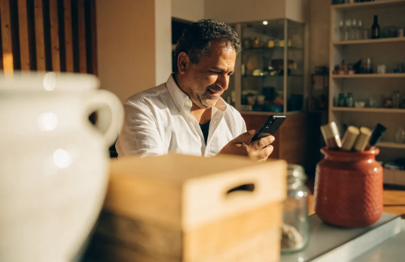 Empresário atendendo clientes pelo celular na loja
